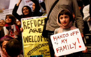 Gurna holds a sign in support of Muslim family members as people protest the travel ban on Muslim majority countries in Los Angeles, California